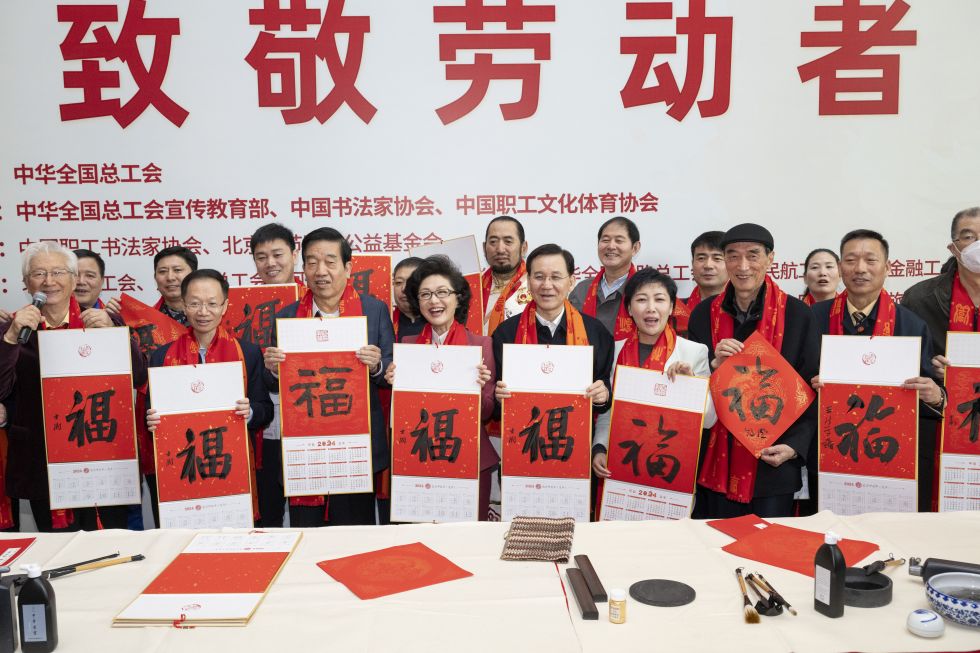 2024年1月16日,在北京的中国职工之家举行的万福迎春——2024年“送万福、进万家”书法公益活动上,劳模与职工代表们展示书法家们写的福字。新华社记者 才扬 摄
